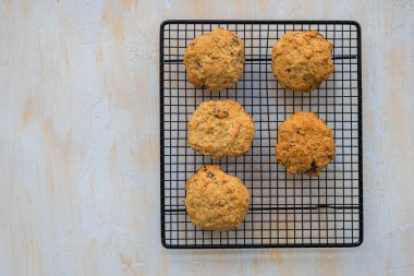 Muz ve çikolatalı ev yapımı yulaf ezmesi kurabiyeleri açık beton arka planda siyah tel askıda. Yulaf ezmesi..