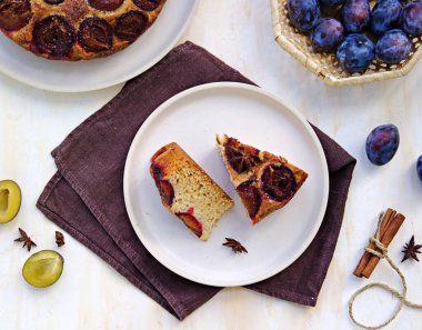 Dilimlenmiş ballı kek ya da açık beton arka planda açık rende taze erikli kek. Erikli ürünler. Şükran Günü.