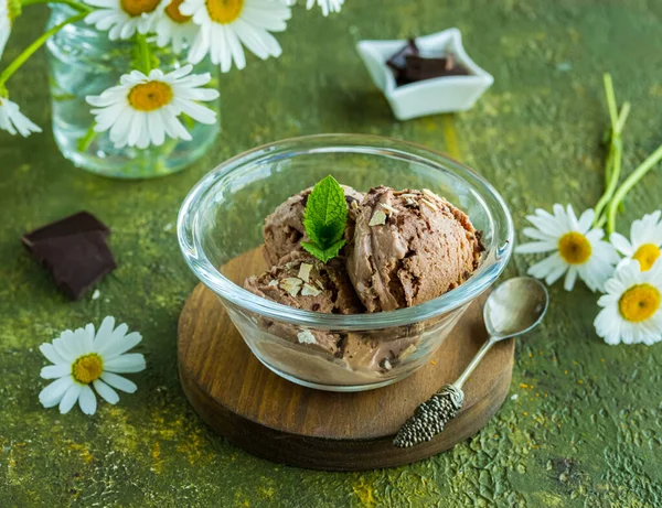 Üç kepçe ev yapımı çikolatalı dondurma yeşil beton arka planda cam bir kasede. Dondurma tarifleri.