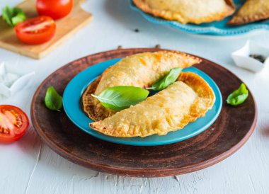 Chebureks ya da börek, hafif beton arka planda mavi tabakta kızartılmış geleneksel etli turta. Kızarmış hamur işleri..