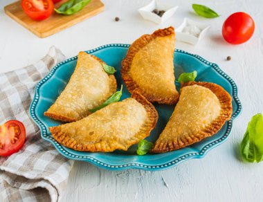 Chebureks ya da börek, hafif beton arka planda mavi tabakta kızartılmış geleneksel etli turta. Kızarmış hamur işleri..