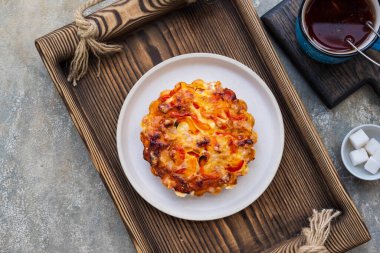 Tatlandırılmamış turtalar ya da ahşap tepside seramik tabakta yumurta, tavuk, dolmalık biber ve peynirli mini tart. Tuzlu hamur işleri