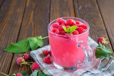 Geleneksel Rus sıcak içeceği ahududu reçeli ya da kahverengi ahşap arka planda şeffaf bir bardakta öpüşmek. İçme tarifleri.