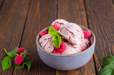 Kahverengi ahşap arka planda seramik kasede taze ahududu aromalı ahududu dondurması. Dondurma tarifleri. Yaz konsepti