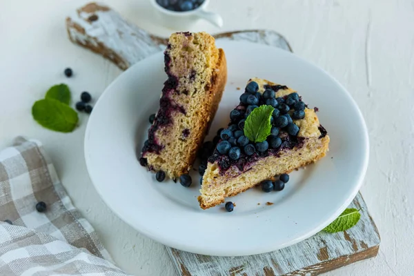 将蓝莓海绵蛋糕切成薄片 放在白色的盘子里 放在轻混凝土的背景上 烤浆果 美国食品 — 图库照片
