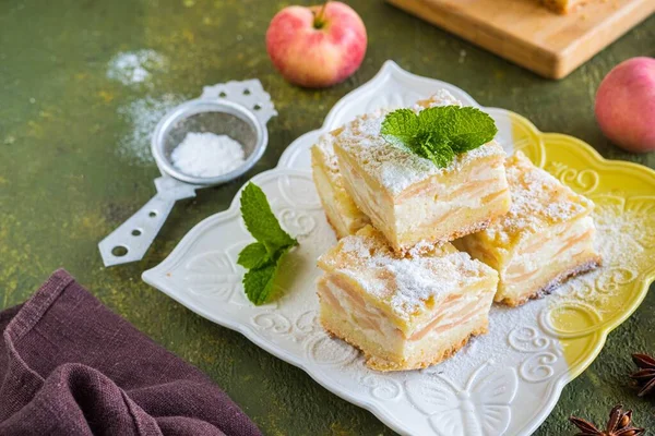 用酥皮糕点制成的切片苹果派 在绿色混凝土背景的正方形盘子上夹有奶酪奶油和苹果片 苹果派配方 感恩节 — 图库照片