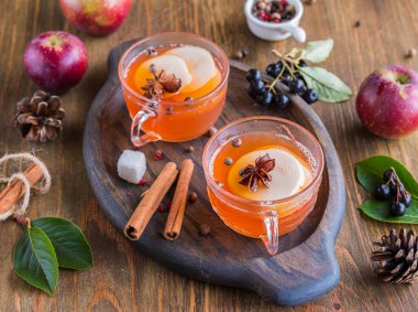 Sonbahar içkisi, elma suyu, elma dilimleri ve ahşap bir tepside. Amerikan mutfağı. Şükran Günü