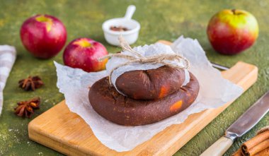Litvanya tatlısı, yeşil arkaplan betonu üzerinde ahşap bir tahtada baharat bulunan peynir kafaları şeklinde elma meyveli şeker. Noel tatlıları. Elma hasadı, konserve