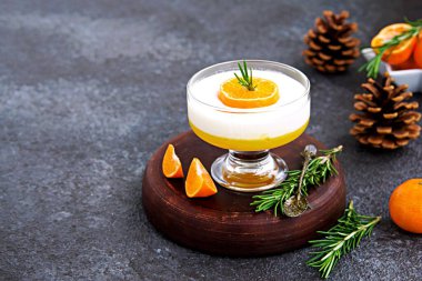 Tatlı, mandalina katmanlı vanilyalı panna cotta küçük porsiyonlu bir vazo ve koyu beton arka plan. Noel ve Yeni Yıl konsepti. Çince Tatlılar.