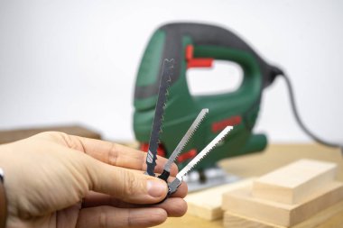 Modern elektrikli testerenin yapboz dosyaları. Ev ahşap işçiliği. Arkaplanda tahta tahtalar