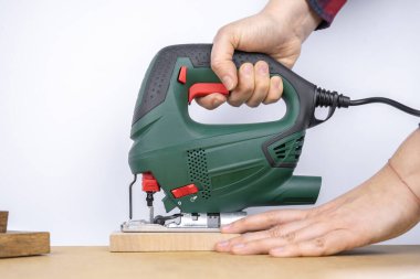 Modern elektrikli testere aletleri DIY ev ahşap işçiliği için kullanılıyor. Arkaplanda tahta tahtalar