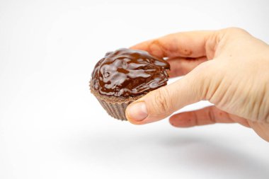 Bir elde ev yapımı çikolatalı kek. beyaz arkaplanda izole