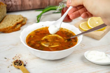 Geleneksel Rus çorbası solyankası. Et, limon ve zeytinli Hodgepodge çorbası. Ekşi kremayla servis edilir.