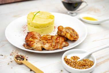 Hardallı kızarmış tavuk ve beyaz tabakta patates püresi ile bal sosu.