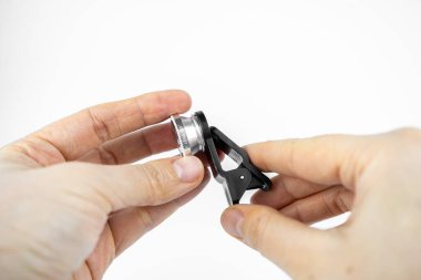 Beyaz arka planda klipsleri olan fotoğraf objektifi. Akıllı telefon için ekstra makro kamera