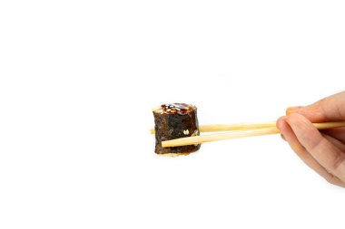 Beyaz arka planda bambu çubukları olan unagi maki dürümleri, Asya yemekleri, Japon mutfağı.