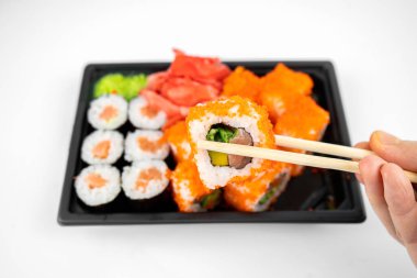 Suşi rulolarını plastik kutuda, California 'da, somon balıklı rulo, pembe zencefil, wasabi. suşi teslimatı konsepti