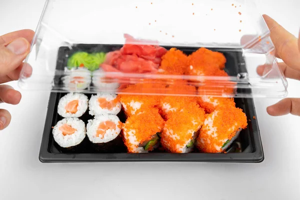 寿司ロールをプラスチック容器に入れカリフォルニアサーモン巻き ピンク生姜 わさび 寿司配達のコンセプト — ストック写真