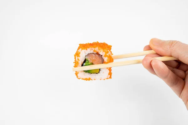 拿一个用竹子筷子做的墨西哥卷 放进酱油里 粉色生姜 亚洲菜 日本菜背景 — 图库照片