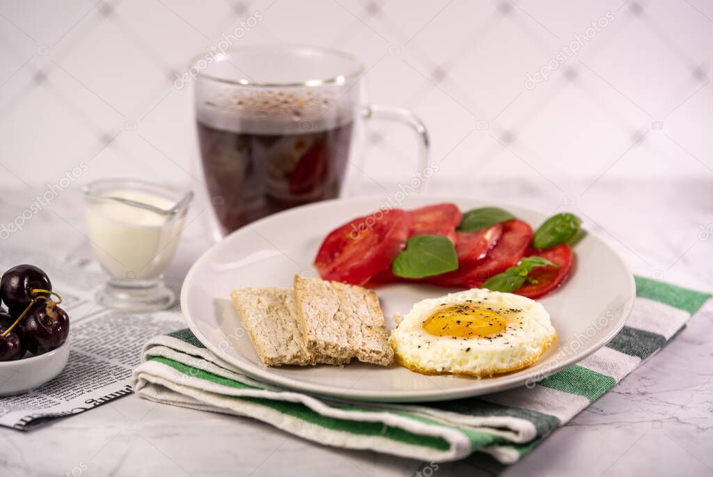 Breakfast with fried egg, tomatoes and crispbread