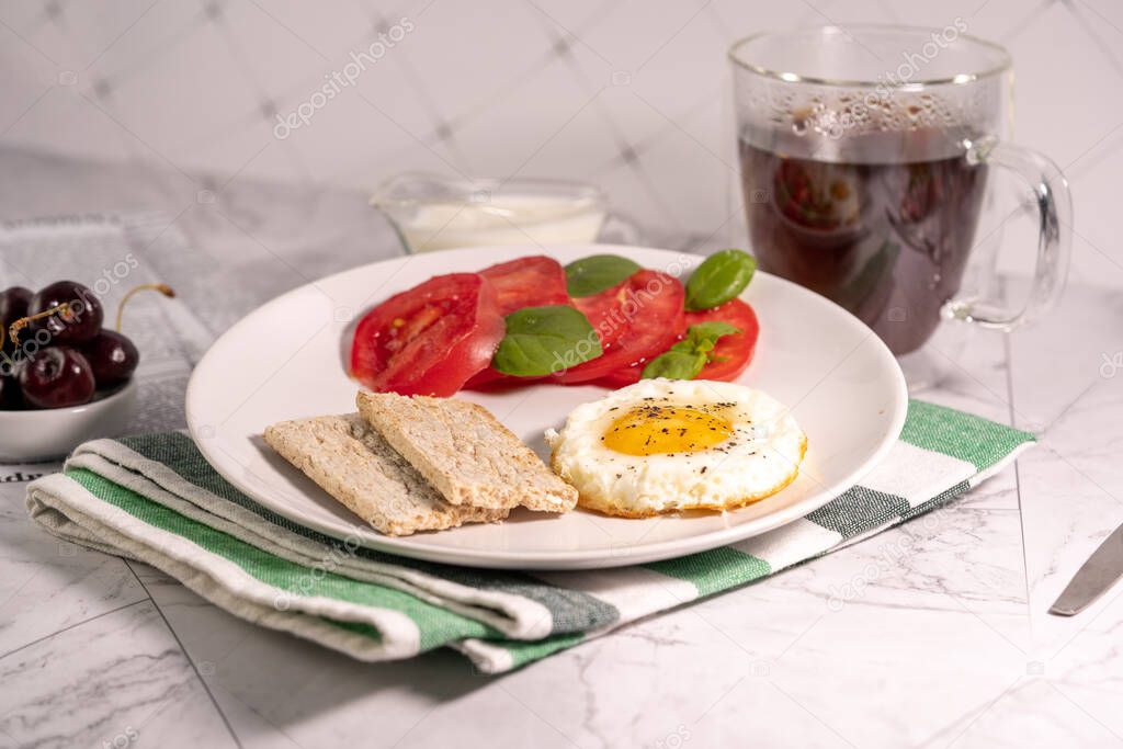 Breakfast with fried egg, tomatoes and crispbread