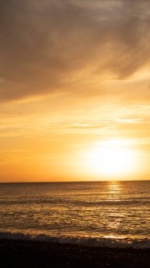 Tropik sahilde inanılmaz bir gün doğumu. Denizin üzerinde sarı güneş. Turuncu renk dalgaları. Doğa geçmişi. Güzel sakin bir sahne. - Günaydın. Güneş ışığı su yüzeyine yansıyor