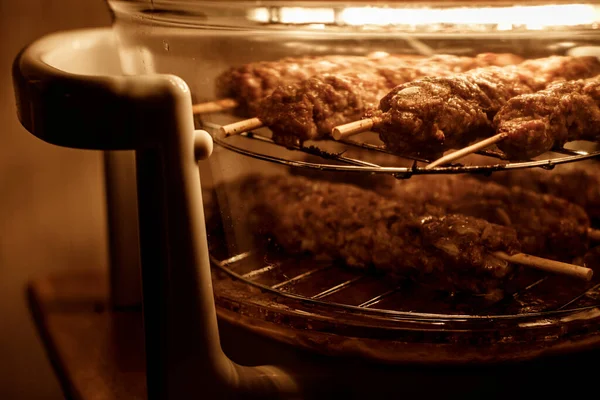 Ev mangalının seçici odak fotoğrafı. Havalandırma ızgarasında lulia-kebap (kıyma kuzu shashlyk) pişiriyorum.).