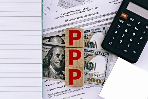 fotoğraf on ppp (maaş çeki koruma programı) teması. Dolar banknotlarının arka planında 