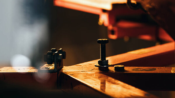 selective focus photo of the fragment of print screening apparatus. serigraphy production. printing images on t-shirts by silkscreen method in a design studio