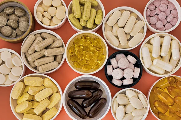Mercan arka planında biyolojik olarak aktif multivitamin takviyeleri var. ruh sağlığı ve kişisel sağlık konsepti