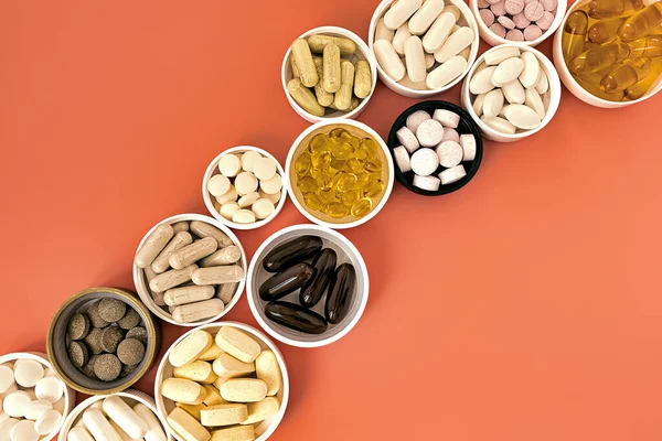Mercan arka planında biyolojik olarak aktif multivitamin takviyeleri var. ruh sağlığı ve kişisel sağlık konsepti