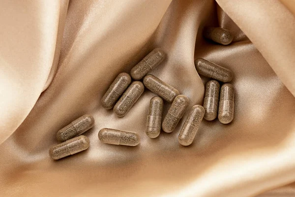 İpek arka planda beslenme takviyesi multivitamin karmaşık kapsülleri. ruh sağlığı ve kişisel sağlık konsepti