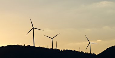 Gün batımında yel değirmenlerinin siluetleri