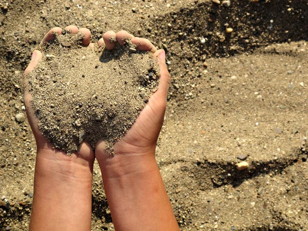 Sand i händerna på barnet — Stockfoto