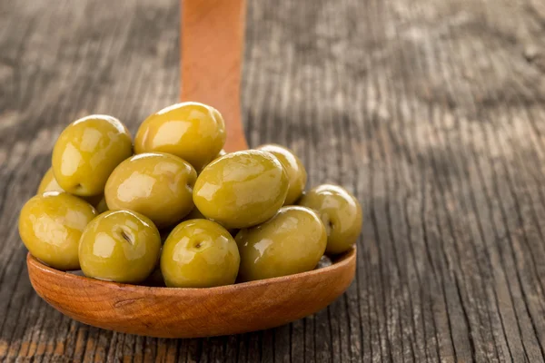 Olives in wooden spoon — Stock Photo, Image