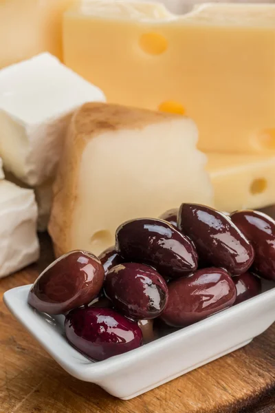 Olives et fromage sur planche de bois — Photo