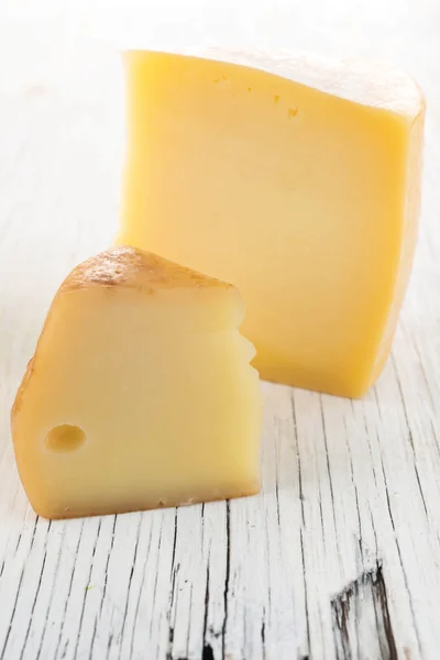 Žlutý sýr na dřevěný stůl — Stock fotografie