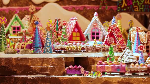 A toy city of gingerbread houses and a railway. The train drivers travel through the fabulous childrens city. Edible gingerbread maker with icing. Christmas decoration in the panorama. — Stock Video