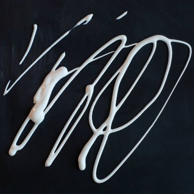 Siyah, yumuşak, pürüzsüz bir zeminde sıvı beyaz boya izleri var. Kuru, ipeksi, siyah bir dokuda beyaz, ıslak, yapışkan boya darbeleri.