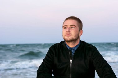 Yakışıklı genç adam akşamları deniz kıyısına bakar..