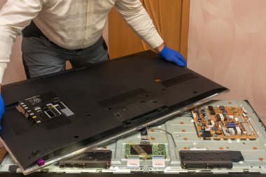 LED TV 'nin tamiri. Usta televizyonun arka panelini kaldırıyor. Seçici odak, yakın plan.