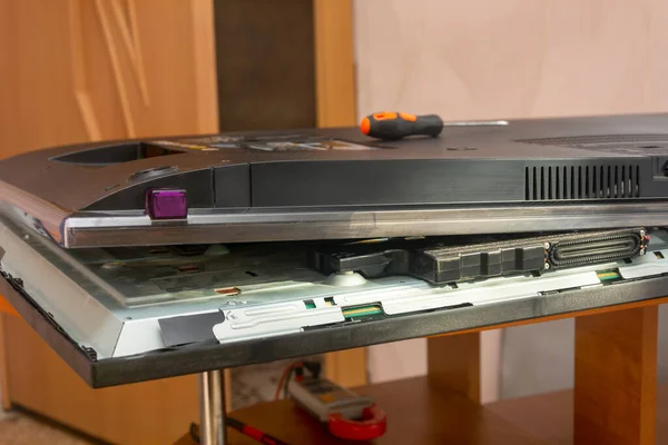 Servis merkezinde kırık bir monitör var. LCD TV 'nin arka panelini aç. Yakın çekim, sığ alan derinliği, seçici odaklanma.