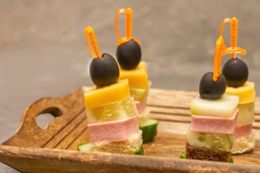 Jambon, peynir, ekmek ve zeytinli nefis kanepeler. Büfe masası, yakın çekim, seçici odak.