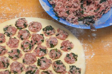 Hamurdan hamur köftesi ve ıspanaklı kıyma. Yakın çekim, seçici odaklanma.