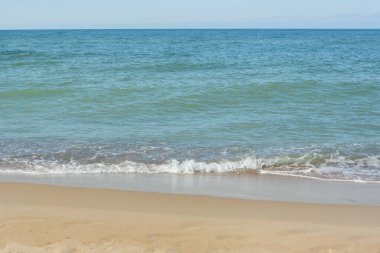 Güzel kumlu sahil ve beyaz köpüklü yumuşak dalgalar, deniz sörfü. Yaz tatili için doğal arka plan.