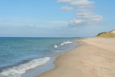 Kum kıyısında beyaz köpüklü yumuşak dalgalar. Tatil ve seyahat kavramı.