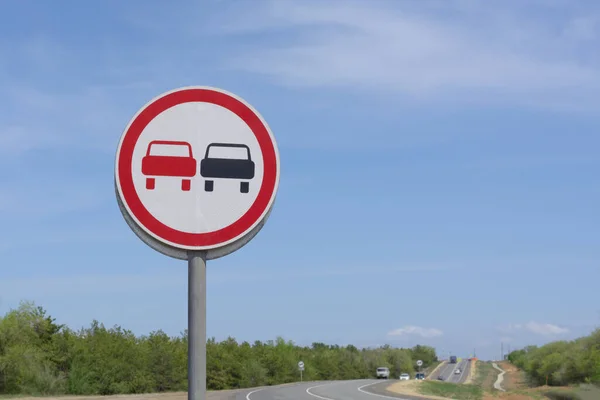 Overtaking is prohibited on round road sign. Warning to drivers on dangerous section of road.