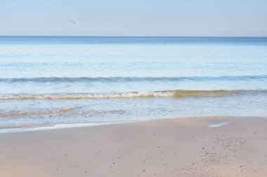 Deniz kıyısındaki akşam kumsalı. Yumuşak kum ve sörf. Sakin, yaz havası. Plaj konsepti.