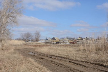 İlkbaharın başında köyün varoşlarında. Kirli yol, güzel gökyüzü ve evler. Kırsal alan.