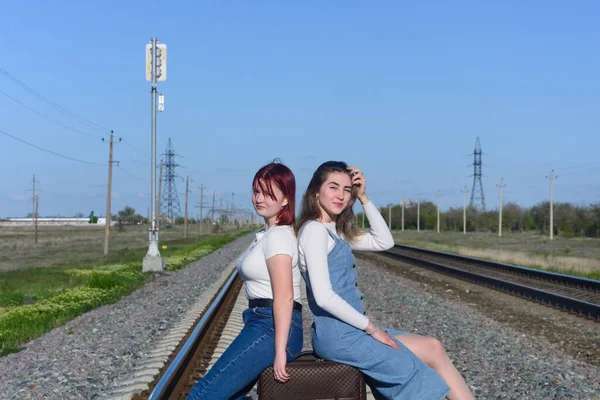 Duas Jovens Estão Sentadas Caminho Ferro Com Mala Espera Comboio — Fotografia de Stock